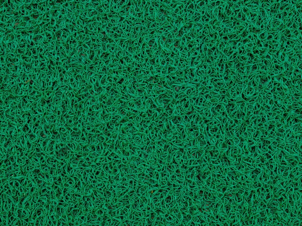 Detailed texture of green artificial grass, ideal for backgrounds and design projects.