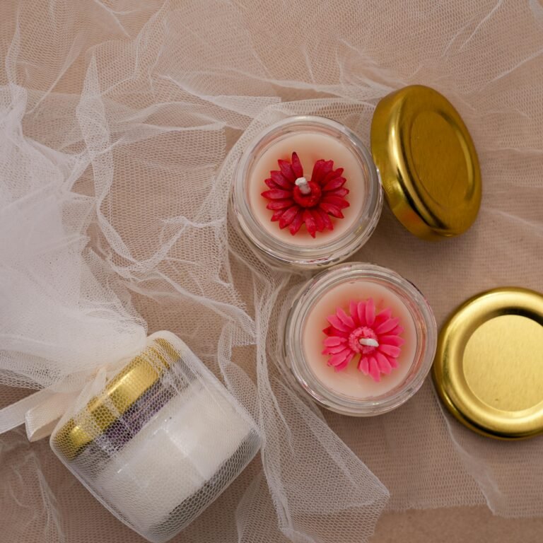 Top view of decorative candles with floral designs and gift wrap, perfect for gifts or home decor.