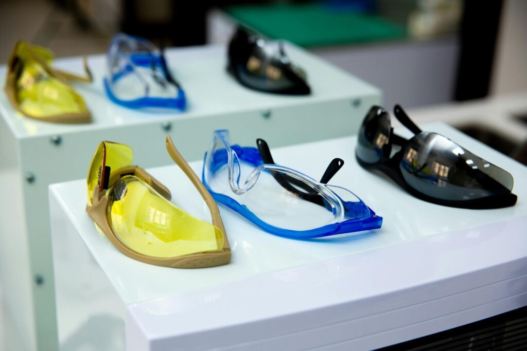 Close-up of different colored protective eyewear on display, featuring yellow, blue, and black designs.