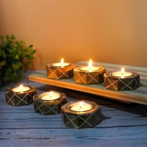A warm setting with lit candles in unique wooden holders on a rustic surface.